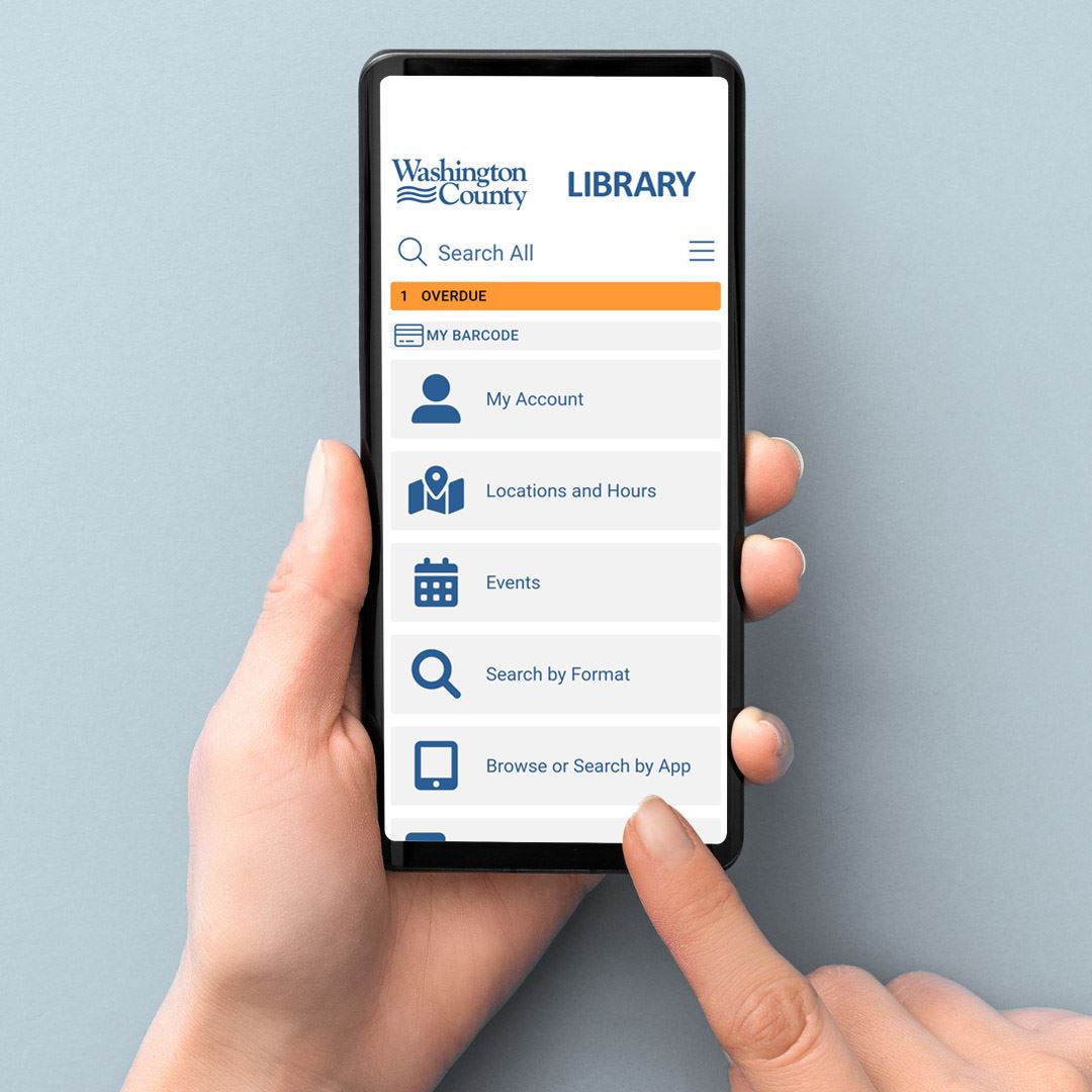 Hand holding a phone with the WashCoLib mobile app on the screen