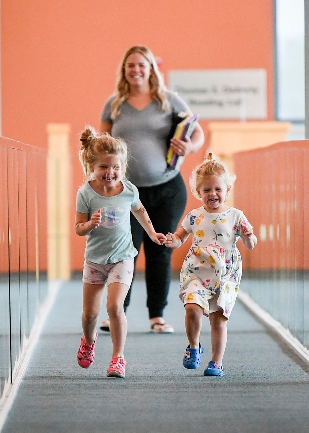 Two girls laughing and running down a ramp at Hardwood Creek Library.